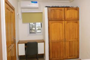 a room with a desk and a wooden door at 1 Bedroom Apartment in Douala