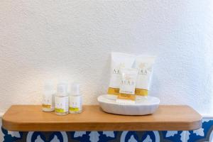 three bottles of moisturizers sitting on a wooden table at Le Perle di Bà - Suites with Jacuzzi in Polignano in Polignano a Mare