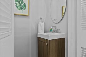 a bathroom with a sink and a mirror at Botanical Bliss | JZ Vacation Rentals in Tower Grove +26 photos