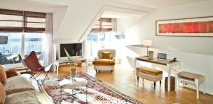 ein Wohnzimmer mit Sofa und Tisch in der Unterkunft CORTIINA Hotel in München