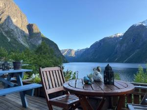 NausteIris Vedal的甲板上的一张桌子和几把椅子，可以欣赏到湖景