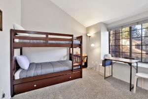 ein Schlafzimmer mit zwei Etagenbetten und einem Schreibtisch in der Unterkunft Restmoore #2425 in Big Bear Lake