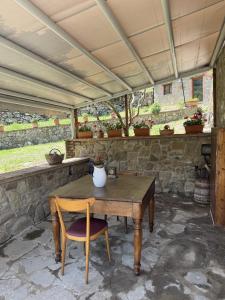a wooden table and a chair sitting under a roof at Casale Agrifoglio - Monterchi in Monterchi +17 photos