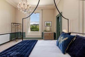 a bedroom with a large bed with a chandelier at The Hutton Suite in Marske