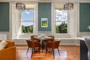 a dining room with a table and chairs and windows at The Hutton Suite in Marske