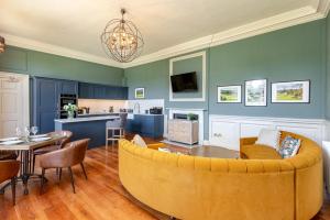 a living room with a yellow couch and a kitchen at The Hutton Suite in Marske +9 photos