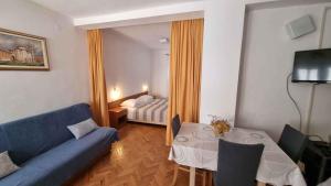 a living room with a blue couch and a table at Apartment Ljubac 2 in Ljubač