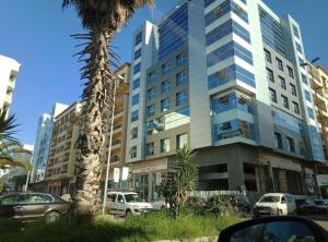 a tall building with cars parked in front of it at Horizon Relax in Mohammedia