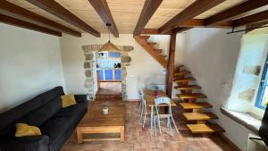 a living room with a black couch and a staircase at Gîte de charme - 30 min de la Mer & Puy du Fo in Belleville-sur-Vie