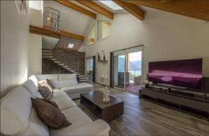 a living room with a white couch and a flat screen tv at NEW! Villa l'or bleu -DUPLEX & MAINFLOOR- by Les éclectiques in Sévrier