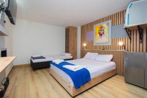 a bedroom with two beds and a tv in it at Hotel Lares 70 Laureles in Medellín