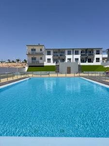 a large blue swimming pool in front of a building at El beso del mar in Costa de Antigua