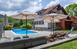 a patio with two umbrellas and a swimming pool at Awesome Home In Novo Zvecevo With Sauna in Novo Zvecevo +29 photos