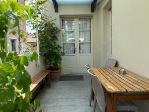 a porch with a wooden table and a bench at Il Cortiletto in Piacenza