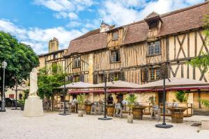 a large building with tables and chairs in front of it at La suite du centre ville, proche cœur historique in Bergerac