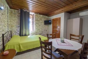 a room with a bed and a table and chairs at AtESI HOUSE-LEFOKASTRO in Lefokastro