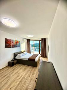 a bedroom with a bed and a large window at Cabacum Pleasure Beachfront Apartments in Varna City