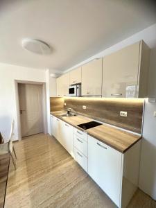 a kitchen with white cabinets and a sink at Cabacum Pleasure Beachfront Apartments in Varna City
