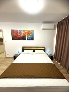 a bedroom with a bed and a painting on the wall at Cabacum Pleasure Beachfront Apartments in Varna City