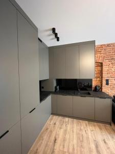 ウッチにあるApartament No 19の白いキャビネットと木製の床を備えたキッチン +9枚の写真