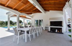 a dining room with a table and chairs and a fireplace at Awesome Home In Sestanovac in Šestanovac