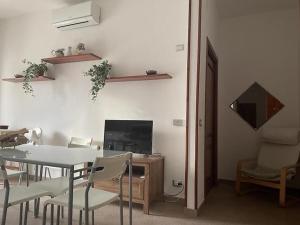 a dining room with a table and chairs and a television at Palazzo Galante in Ginosa Marina