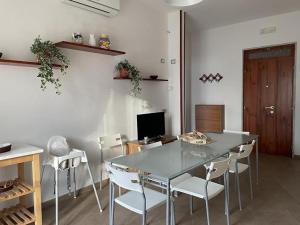 a dining room with a table and white chairs at Palazzo Galante in Ginosa Marina
