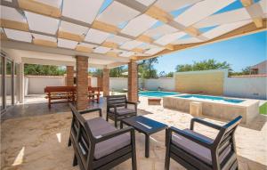 un patio avec des chaises et une piscine dans l'établissement Cozy Home In Radosinovci With Kitchen, à Radošinovac