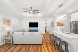 a living room with a white couch and a kitchen at Laguna Peach: 3BA 2BA retreat for 10! Explore nearby beaches & activities in Laguna Beach