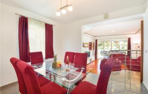 a dining room with a glass table and red chairs at Gorgeous Home In Sinj in Sinj