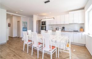 a kitchen with white cabinets and a table and chairs at Stunning Home In Mlini in Mlini
