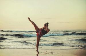 a woman dancing on the beach near the ocean at Jungles Edge Hotel, Jiu Jitsu, Muay Thai Retreat Center in Nosara