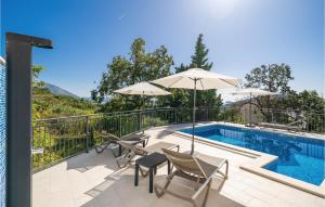 a swimming pool with two chairs and an umbrella at Stunning Home In Mlini in Mlini