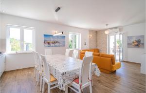 a dining room and living room with a table and chairs at Stunning Home In Mlini in Mlini