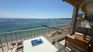 einen Balkon mit einem Tisch und Strandblick in der Unterkunft Palm Beach Amazing view in Cannes