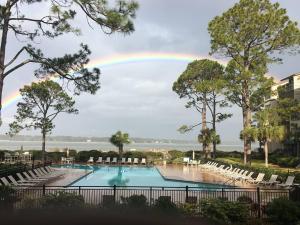 tęcza na niebie nad basenem z krzesłami w obiekcie 1850 Beachside Tennis at The Sea Pines Resort w mieście Hilton Head Island