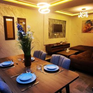 a dining room table with a vase of flowers on it at Sophia in Oujda