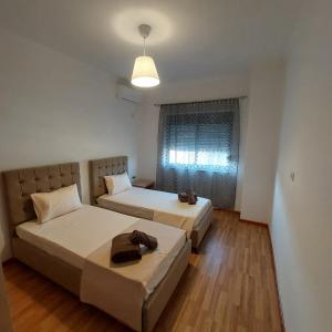 a bedroom with two beds and a window at Delilaj apartment in Përmet