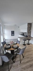 una sala da pranzo con tavolo e sedie e una cucina di APARTAMENT REGAL PARK 59 Elbląg a Elblag