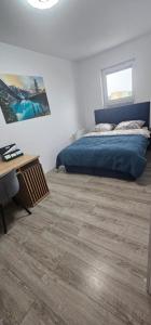 una camera da letto con un letto e un pavimento in legno di APARTAMENT REGAL PARK 59 Elbląg a Elblag