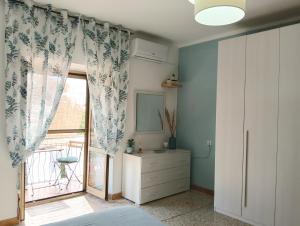 a bedroom with a sliding glass door with a window at Limpida Casa Vacanza in San Nicola Arcella