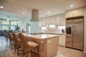 une cuisine avec un îlot avec des chaises et un réfrigérateur dans l'établissement 1864 Beachside Tennis at The Sea Pines Resort, à Île de Hilton-Head