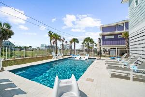 a swimming pool with lounge chairs and a house at Blessed Beyond Measure in Mexico Beach
