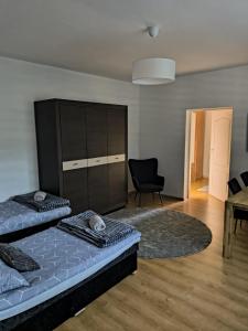 a living room with two beds and a chair at Nocleg pod Orzechem Apartament z 2 pokojami in Wapnica