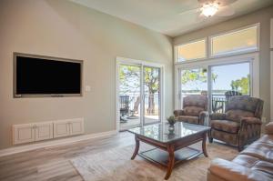 un salon avec une télévision, un canapé et une table dans l'établissement 1864 Beachside Tennis at The Sea Pines Resort, à Île de Hilton-Head