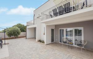 a patio with two chairs and a balcony at 4 Bedroom Gorgeous Home In Vrsi in Vrsi