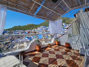 Un balcón de un crucero con suelo a cuadros. en dar lalla chafia 1 studio triplex, en Chefchaouen