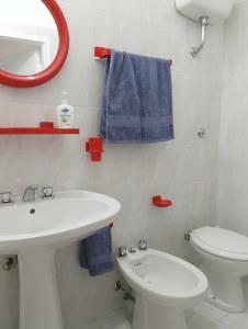a bathroom with a sink and a toilet and a mirror at Limpida Casa Vacanza in San Nicola Arcella