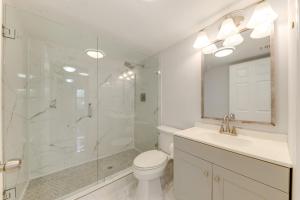 a bathroom with a shower and a toilet and a sink at 1 Mi to Lantana Beach Canal-View Condo with Pool in Atlantis +18 photos