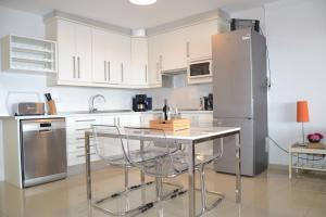 a kitchen with a table and a refrigerator at Looking the VIEWS - 214 in Costa Del Silencio +34 photos